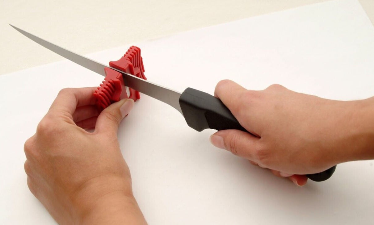 A pair of hands sharpening a knife with the Grooved Ceramic Sharpener.