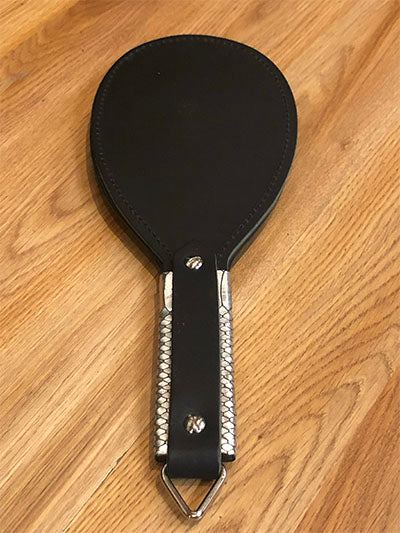 Black round paddle with silver snakeskin print handle.