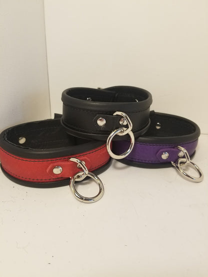 Trio of rolled deluxe collars, one black, one red and one purple.