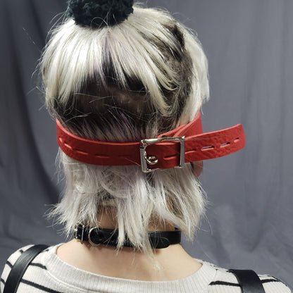 A model showing the buckle of the Red Leather Heart Eye Muffs.