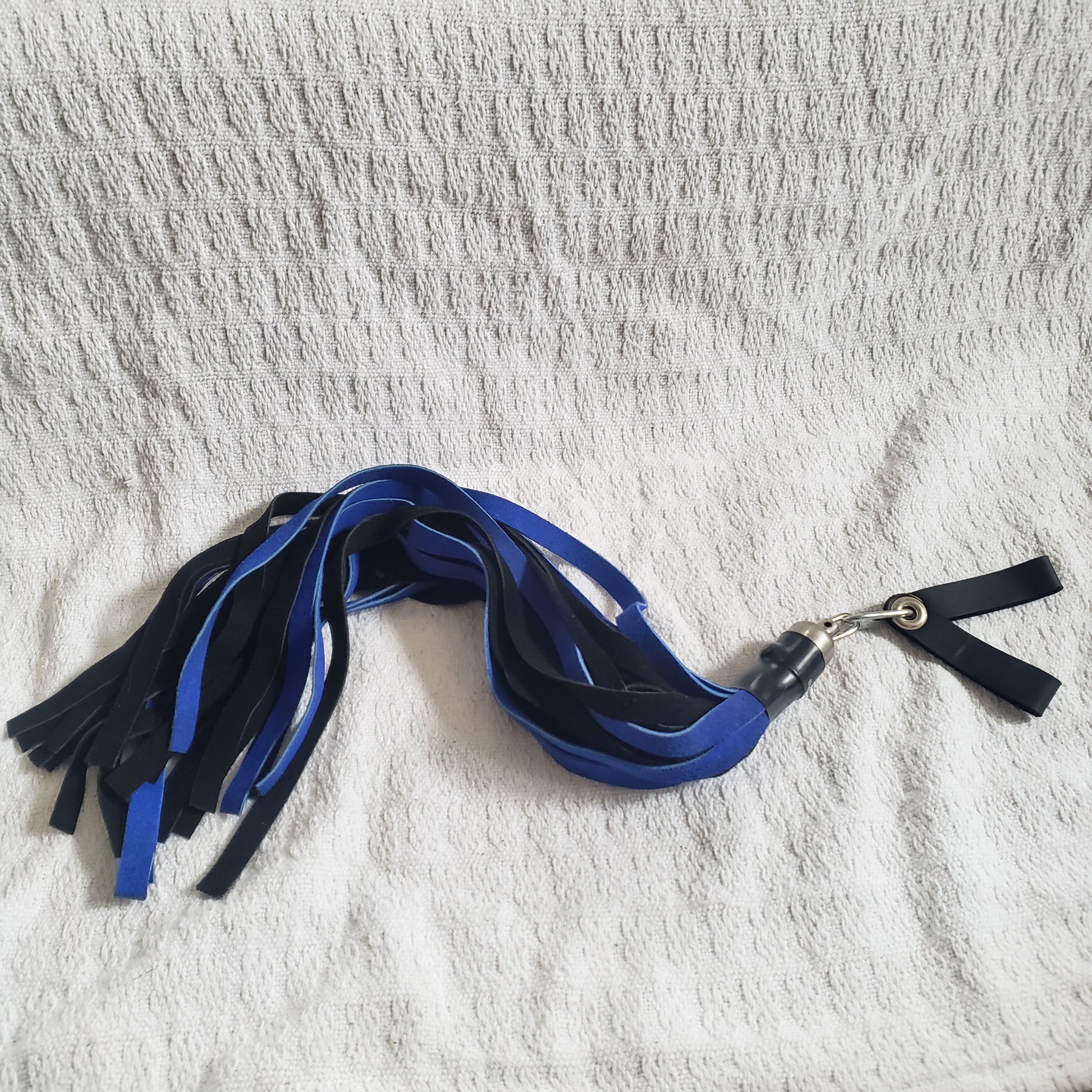 The blue and black suede finger loop flogger.