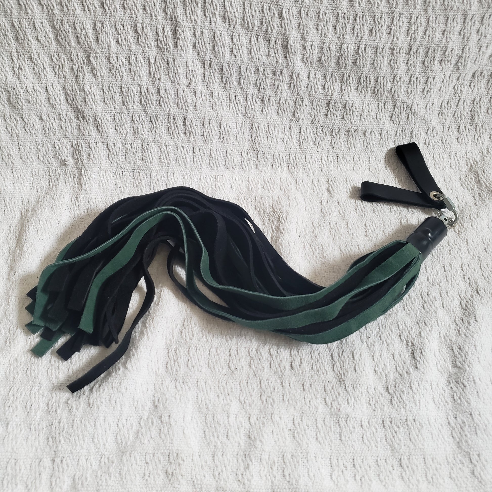 The green and black suede finger loop flogger.