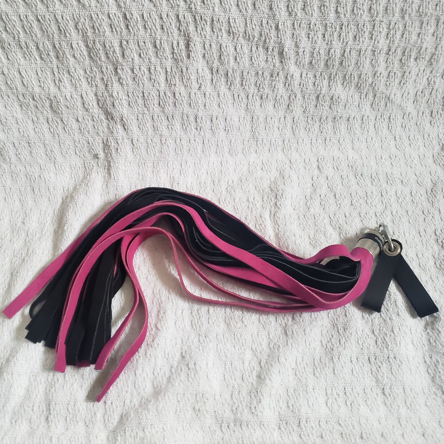 The fuchsia and black suede finger loop flogger.