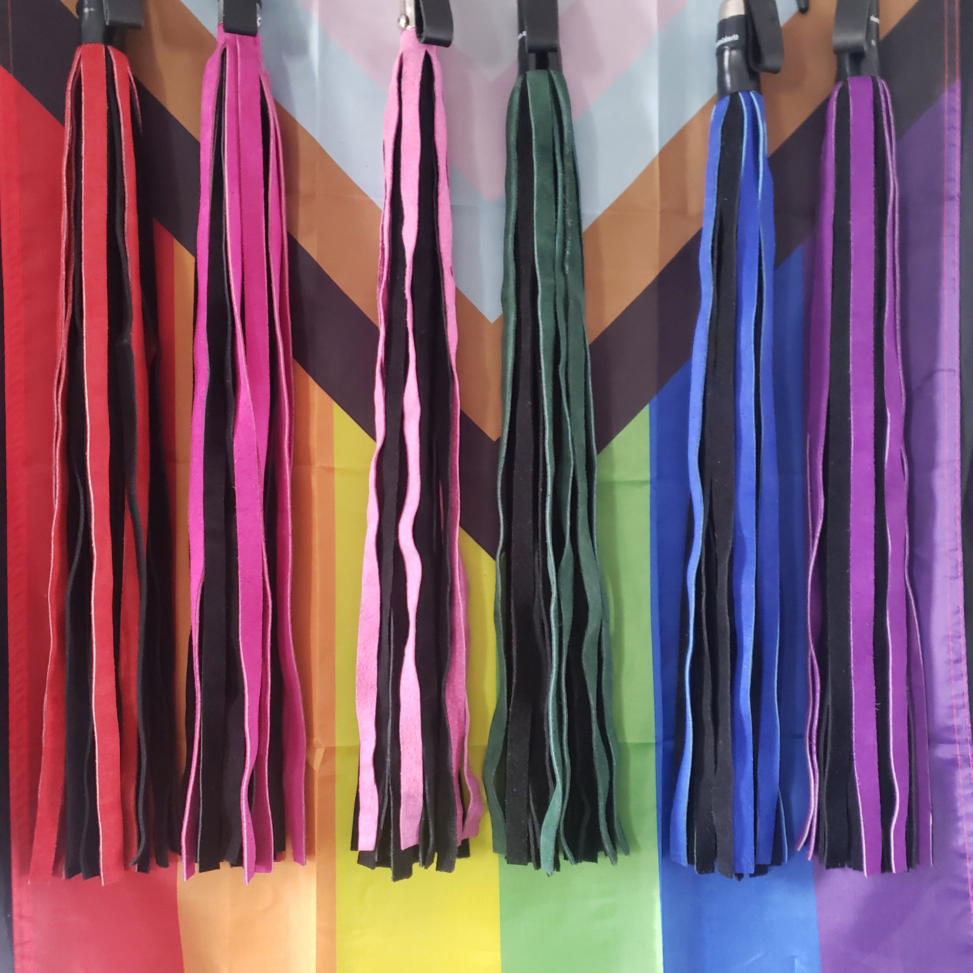 An assortment of colors of the Suede Finger Loop, Flogger in pink, purple, green, blue and red.