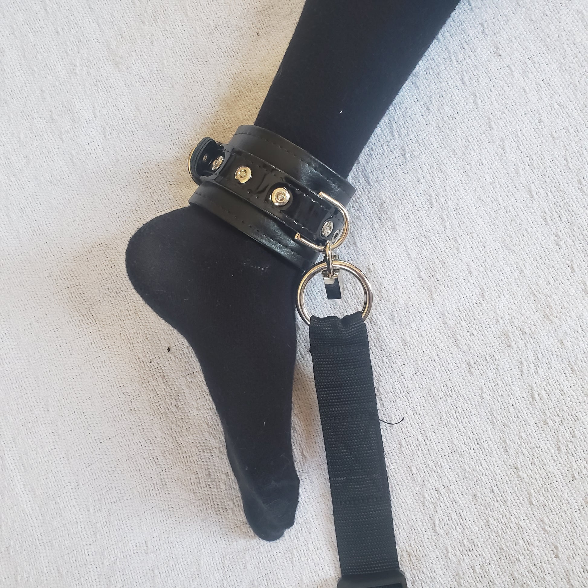 Ankle cuff with strap attached on model's foot.