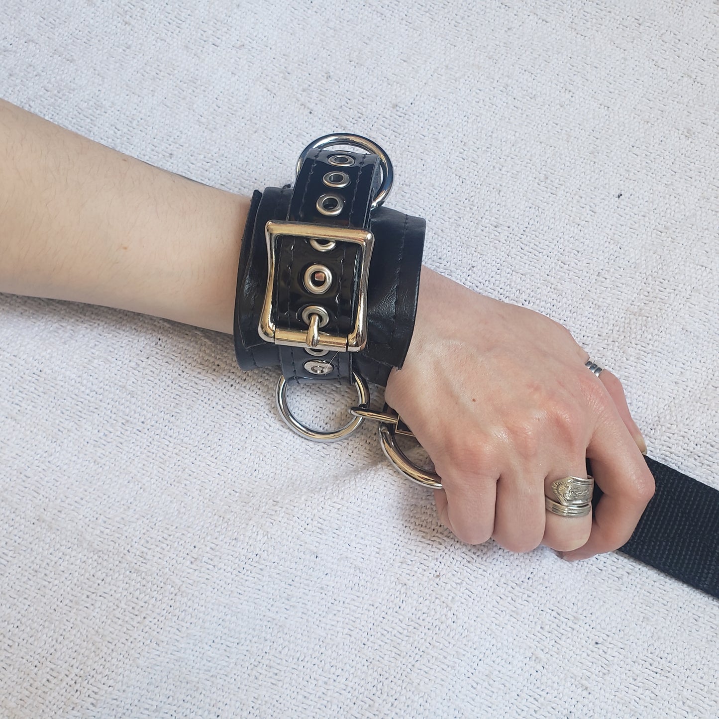 Wrist cuff with strap attached on model's hand. 