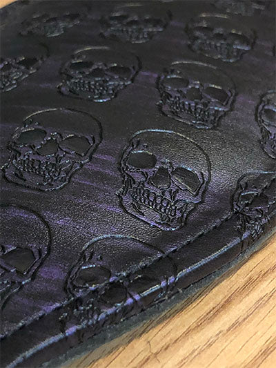 Close up of black and purple round paddle with skull print.