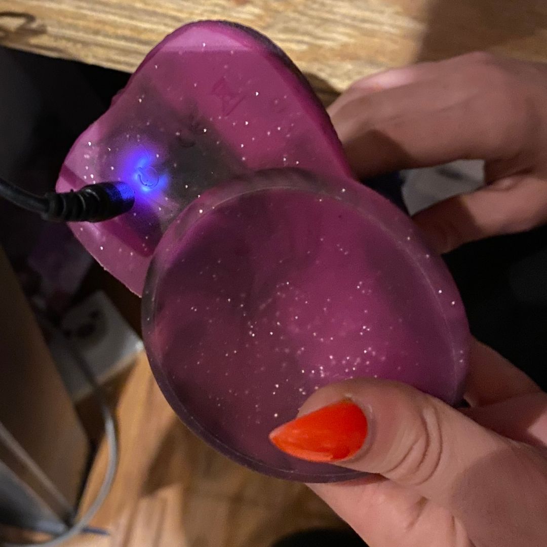 The base of the Stardust Milky Way Vibrating Silicone Dildo plugged into its charger.
