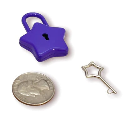 The purple Star Lock and key next to a quarter for size comparison.