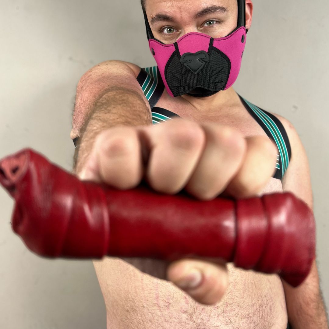 A human pup holding the red Leather Puppy Bonez.