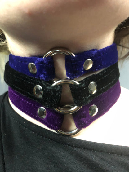 A close up of a model displaying 3 Velvet Chokers, blue, black and purple.
