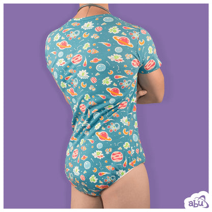 Rear view of model wearing space print diapersuit with disposable diaper worn underneath.