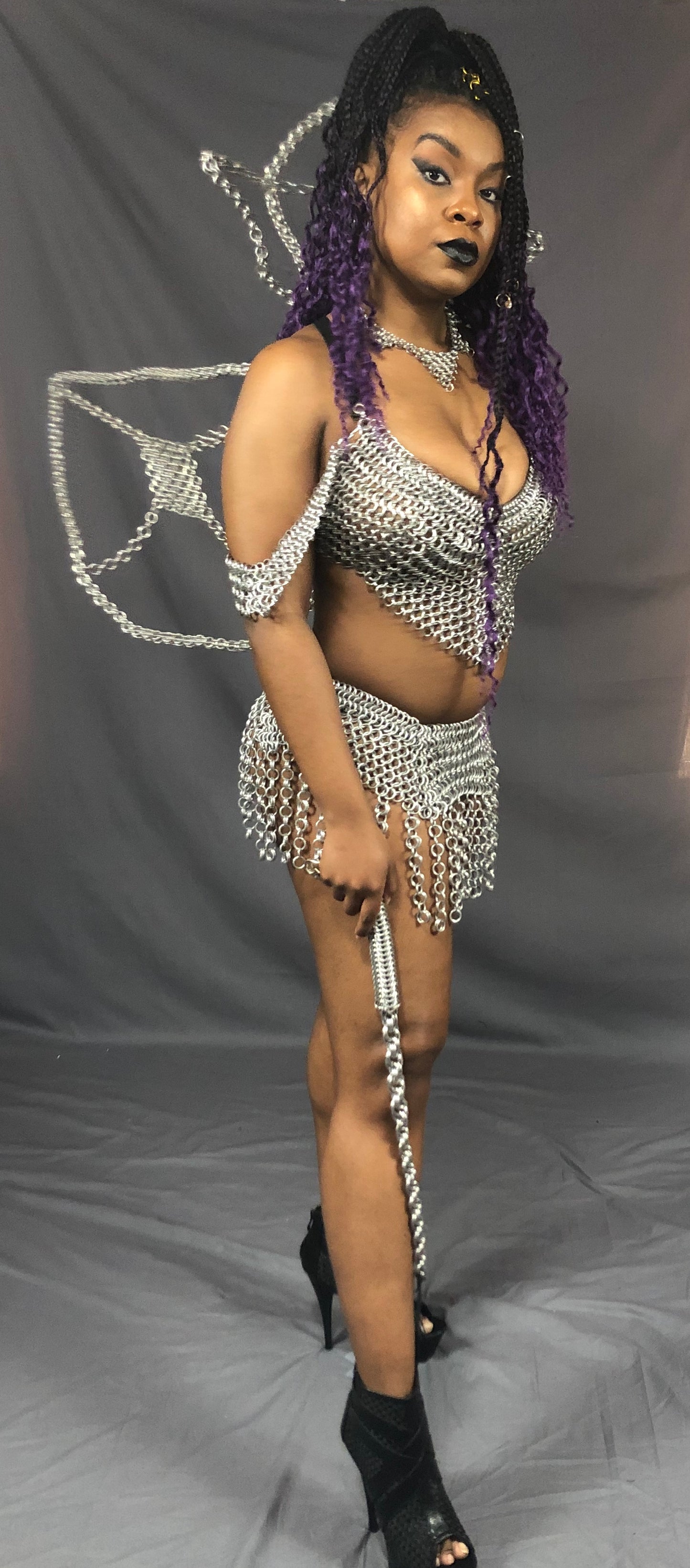 A model wearing a chainmail outfit posing with the Aluminum Chainmail Whip.