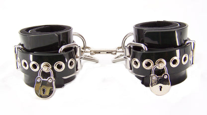 Black PVC neoprene lined bondage cuffs with tentacle eyelets and lock closure against white background.