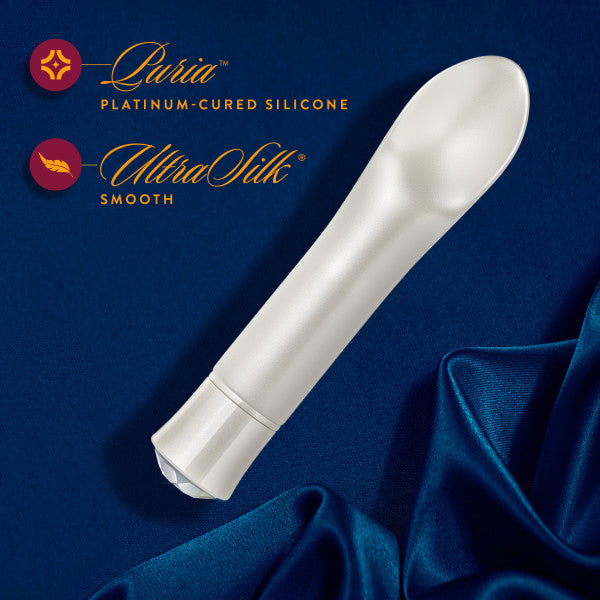 A graphic of the Oh My Gem Bold Diamond Vibrator lying on its side on blue silk next to a description of its materials.