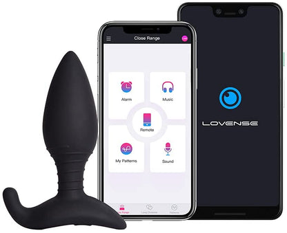 The Lovense Hush 2 Bluetooth Butt Plug Vibrator sitting next to a smartphone that shows its app.