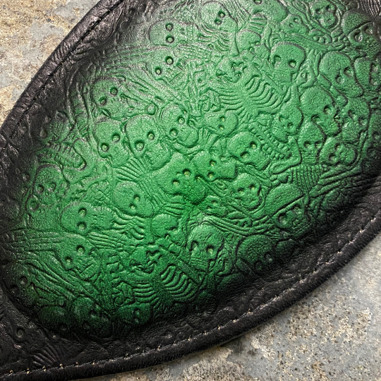 A close up of the green and black two toned Round Paddle with skeleton pattern.