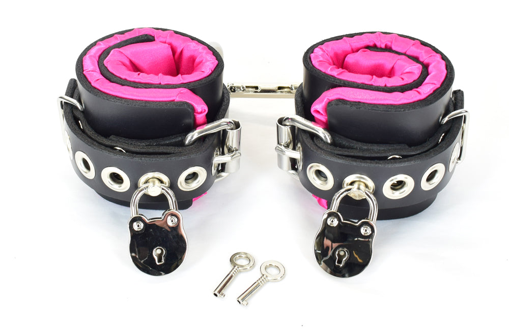 Black with Pink satin lined bondage cuffs with double snap clip connecting cuffs,  tentacle eyelets, locks on both cuffs, and keys.