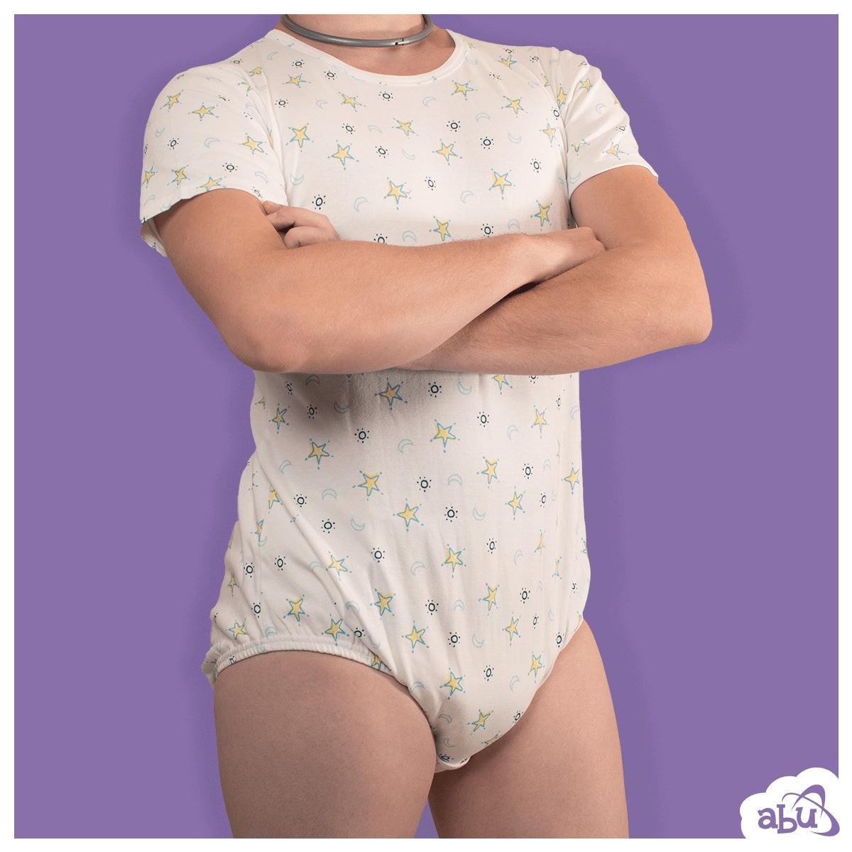 Front view of model wearing moon and stars print diapersuit with disposable diaper worn underneath.