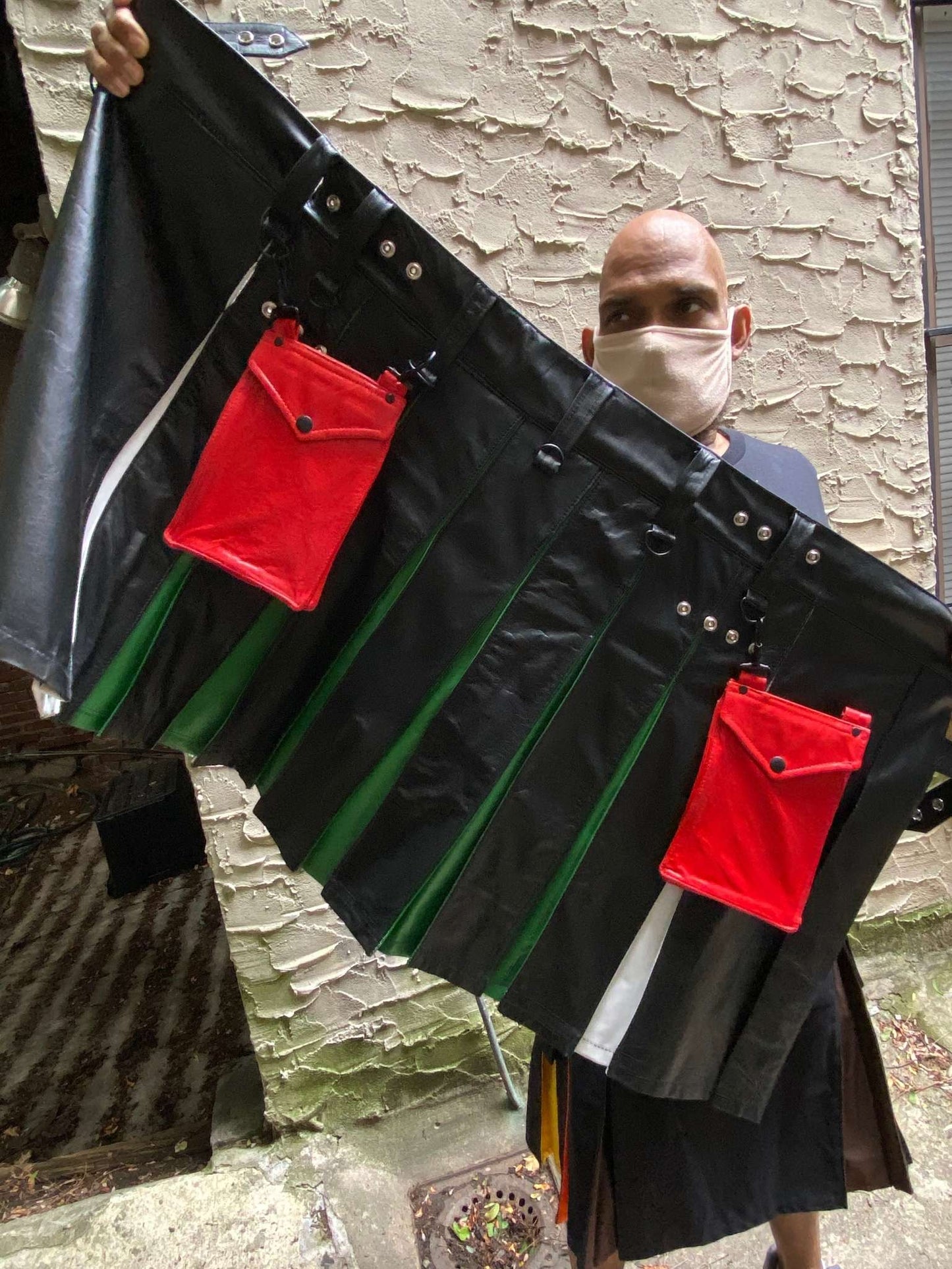 Model holding up leather boy pride flag heritage kilt.