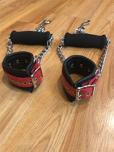 The red pair of detachable grip cuff on a wooden floor.
