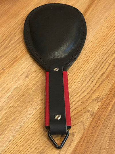 Black round paddle with red and black handle.