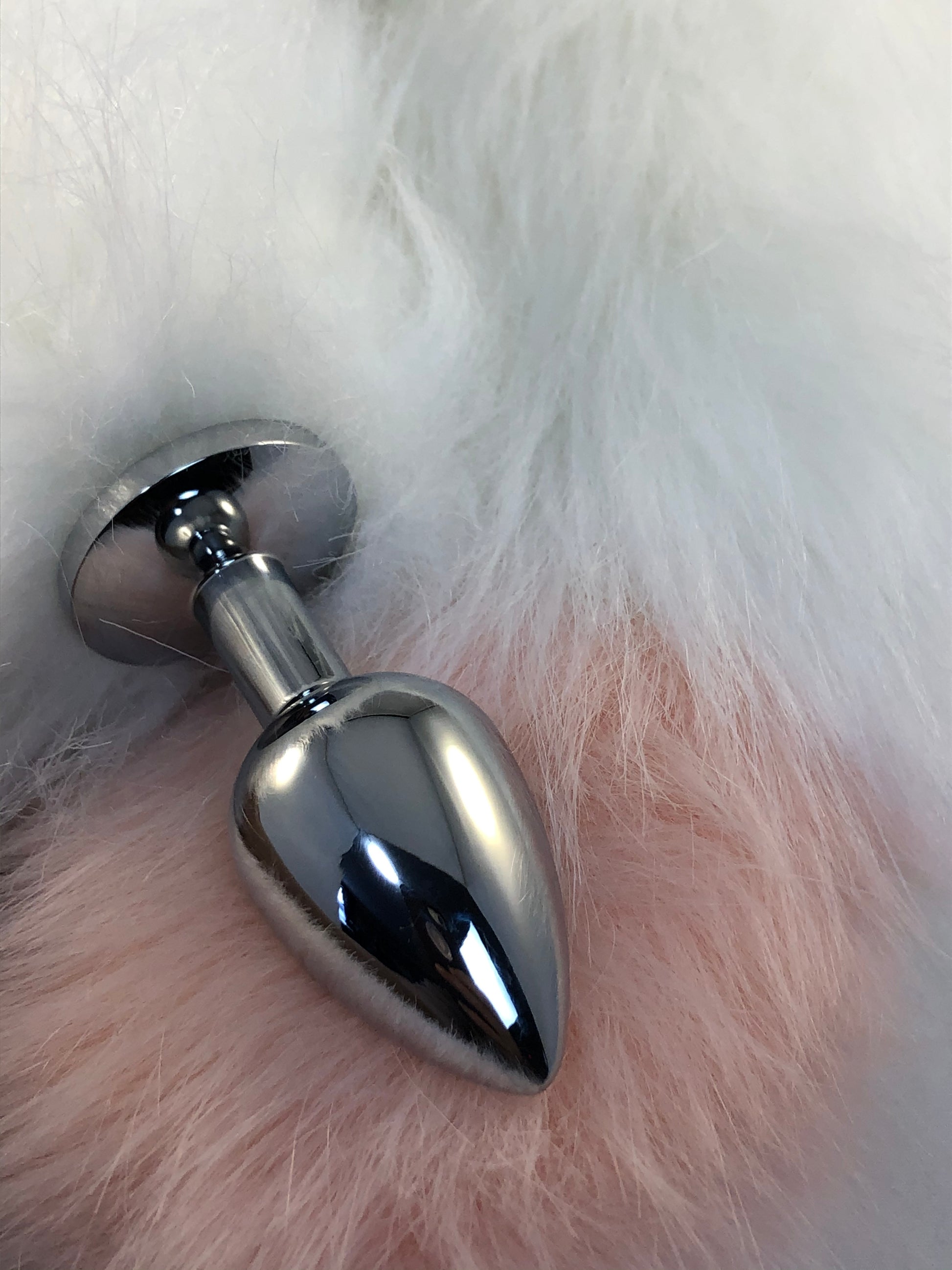 Faux white fur tail with pink tip. Close up of plug and tip.
