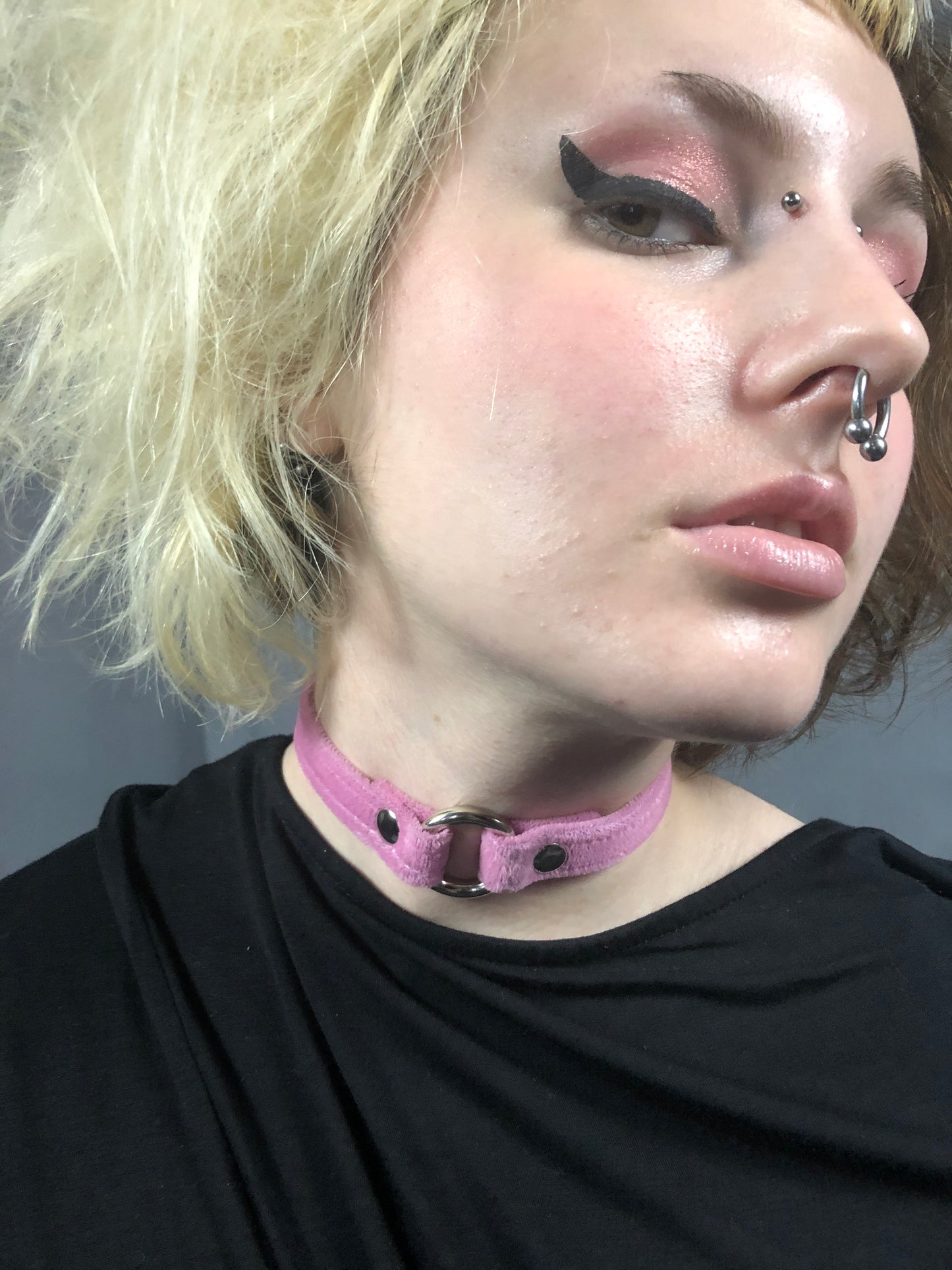 A model with facial piercings, wears a pink Velvet Choker.
