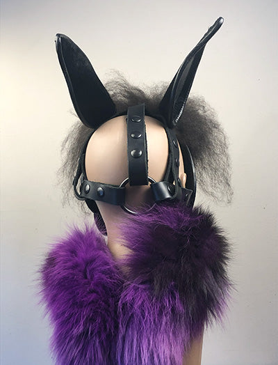 Black leather horse mask on a mannequin, rear view.