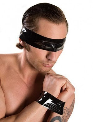 A person who has black bondage tape around his eyes and his wrists.