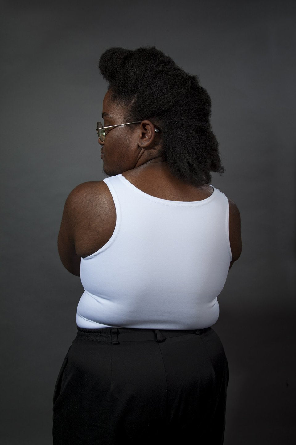 A model showing the back of the long Chest Binder tucked into pants.