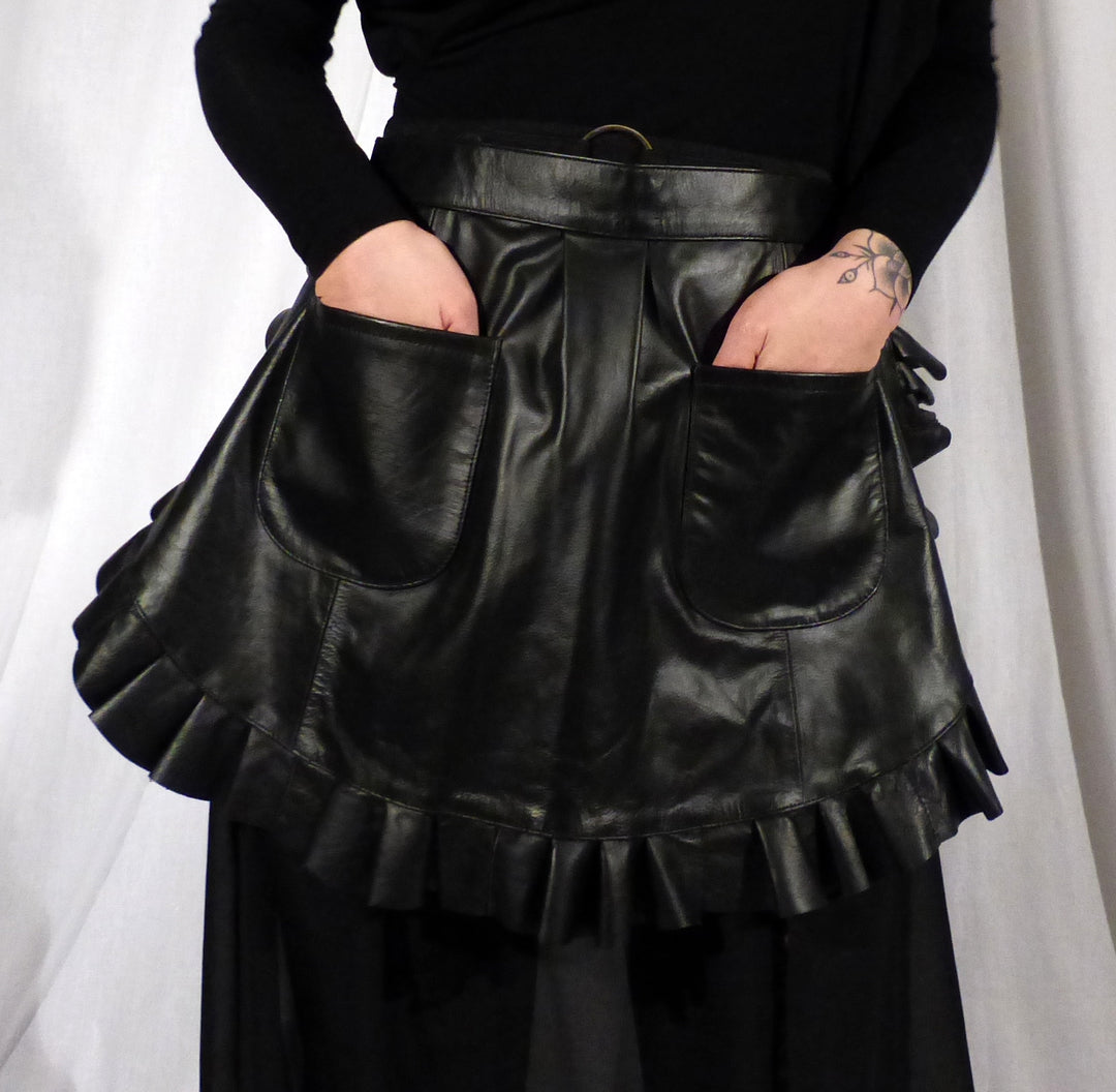 Model with hands in the front pockets of the Leather Ruffle Half Apron.
