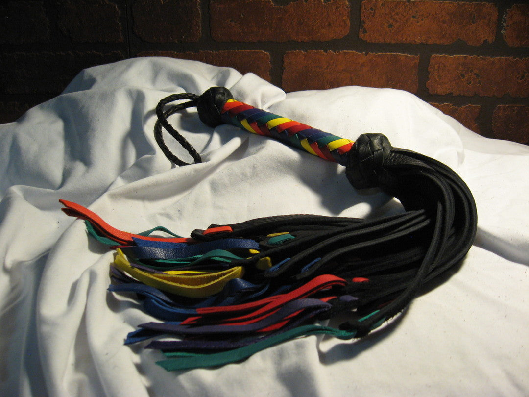 The Rainbow colored Medusa Flogger lying on a white background.