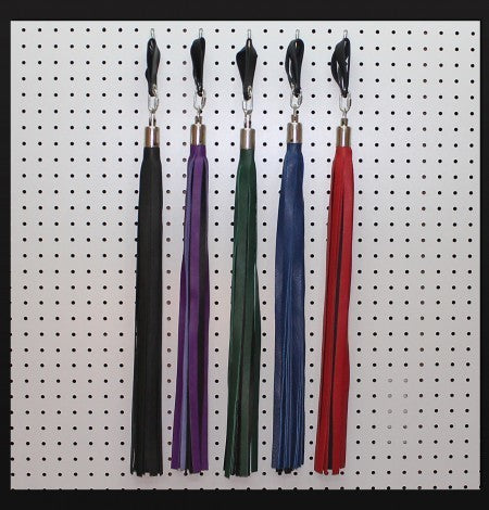 Five Combo Sensation Finger Loop Floggers of various colors hanging from pegs on a white wall.
