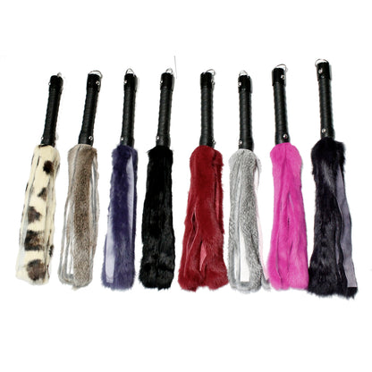 An assortment of Rabbit Fur Floggers with black leather handles and D-ring for hanging.