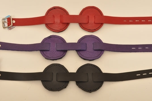 One red, one purple and one black round blindfold lying parallel to each other. 