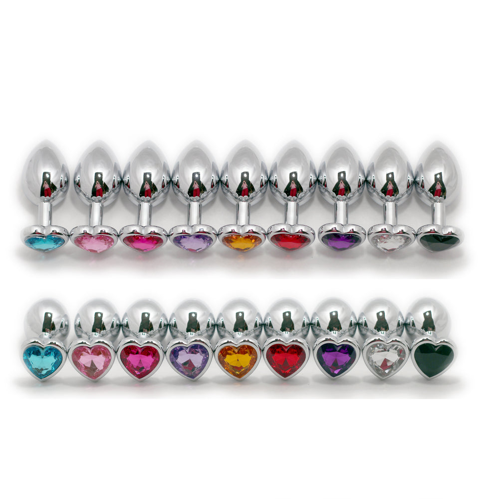 A composite image of nine Steel Heart Jewel Anal Plugs in a row laying on their sides above the same 9 Steel Heart Jewel Anal Plugs featuring the different colored jewels.