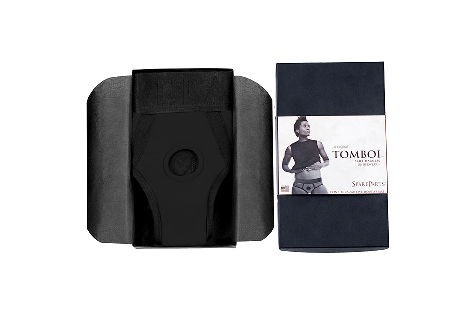The Tomboi Brief Harness next to its packaging.