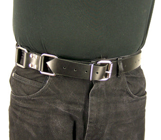 The torso of a man wearing a black t-shirt and black jeans with the Restraint Trick Belt through the loops of his jeans.