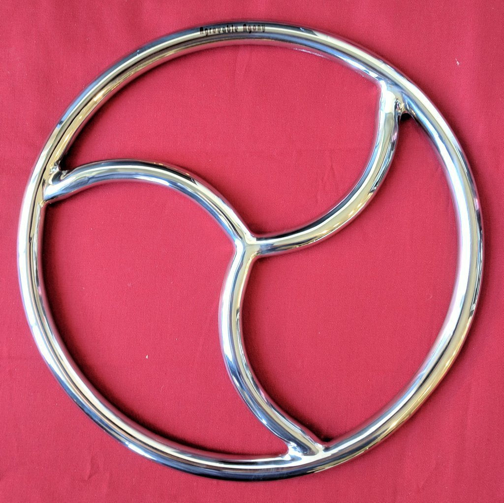 A steel suspension ring with the BDSM triadic symbol inside of it.