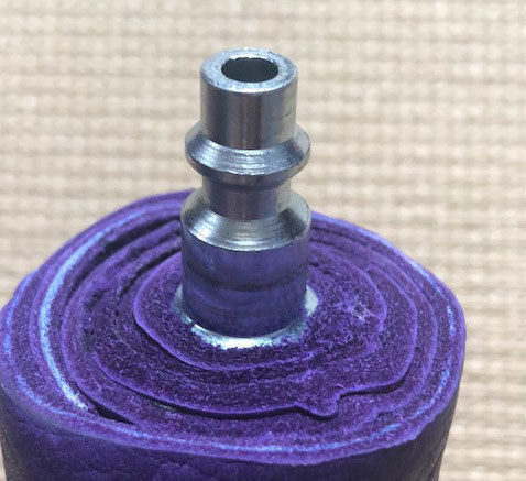 A close up of the screw attachment of a purple Unique Kink Dragon Tail Head.