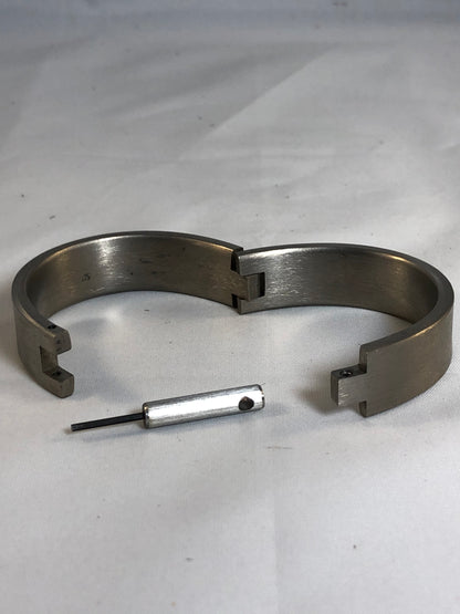 An open Titan Hephaistos Bracelet and its hex key.