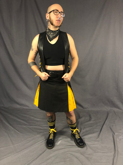 Front view of front & back lace cowhide bar vest with yellow laces, matched with a black kilt with yellow panels and black boots with yellow shoestrings.
