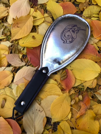 Silver round paddle with black unicorn graphic.