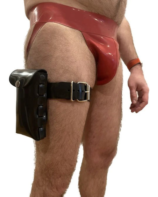 A model wearing a red rubber jock strap wears the Rubber Cell Phone Pouch connected to a Rubber Pouch Strap.