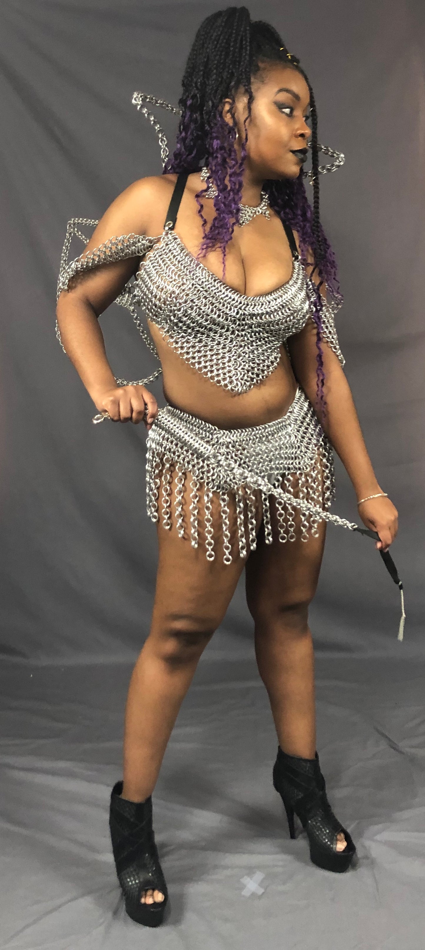 A model wearing a chainmail outfit posing with the Aluminum Chainmail Whip.