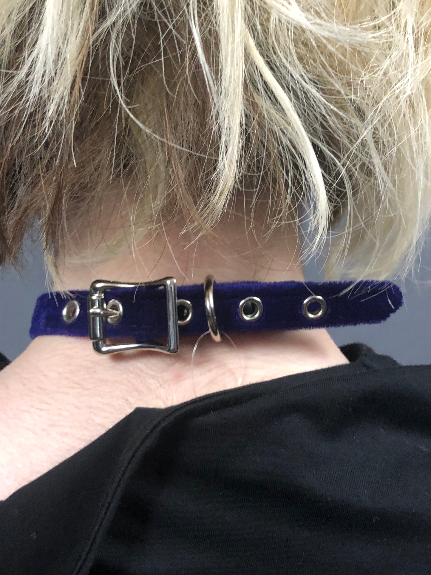 A close up of a model displaying the back of the purple Velvet Choker.