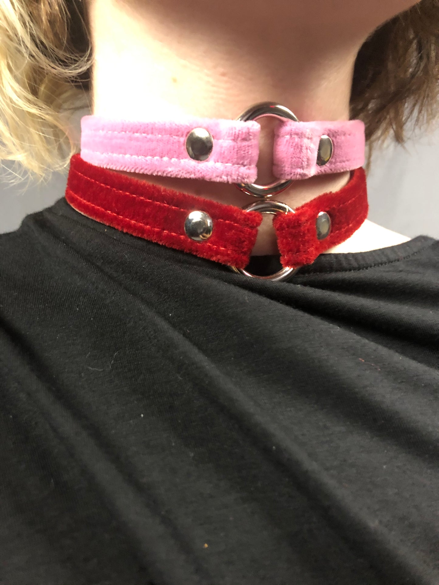 A close up of a model displaying the pink and the red Velvet Choker.