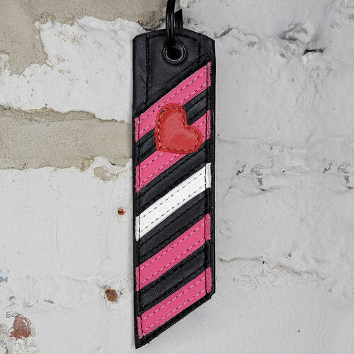 Girl Pride Flag Key Ring Against a Wall