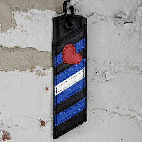 Leather Pride Flag Keyring Against a Wall